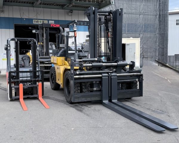 0.9tフォークリフトと10tフォークリフトを正面から撮影。親子のような可愛らしいサイズ差。