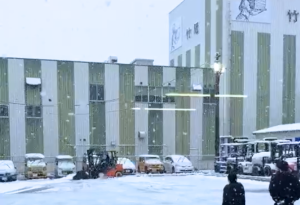 フォークリフトに雪かきバケットを装着して除雪作業を行う様子（仙台営業所）