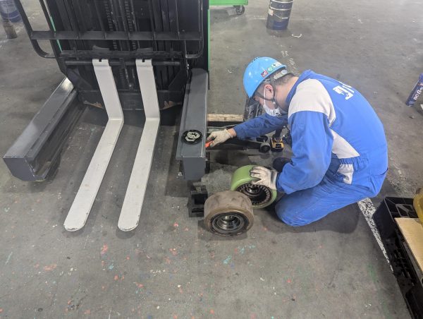 フォークリフトの修理作業を行う整備スタッフ